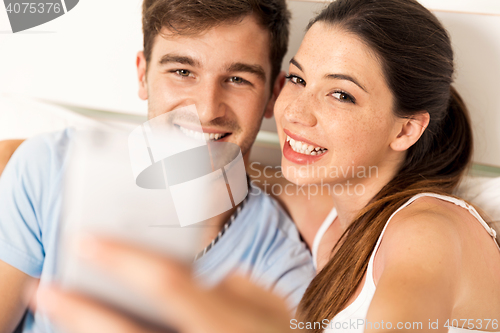 Image of Couple on bed making selfies