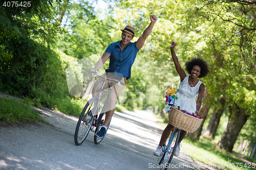 Image of Young multiethnic couple having a bike ride in nature