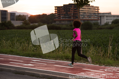 Image of a young African American woman jogging outdoors