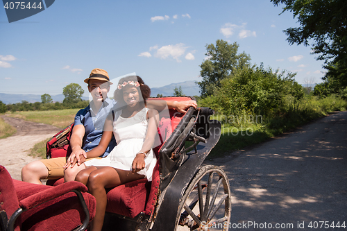 Image of multiethnic couple sitting in a horse carriage