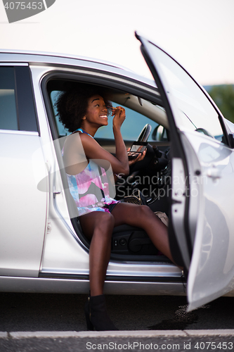 Image of a young African-American woman makeup in the car