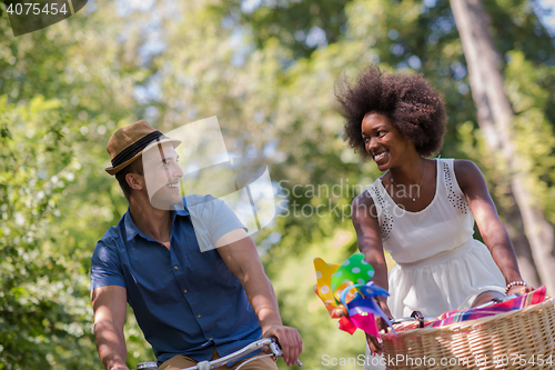 Image of Young multiethnic couple having a bike ride in nature