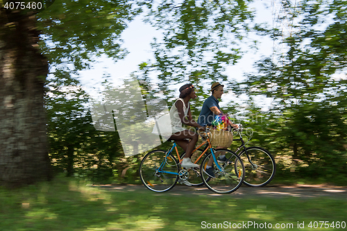 Image of Young multiethnic couple having a bike ride in nature