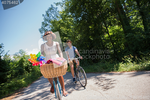 Image of Young multiethnic couple having a bike ride in nature