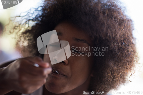 Image of a young African American woman eating pasta