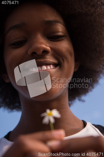 Image of portrait of African American girl with a flower in her hand