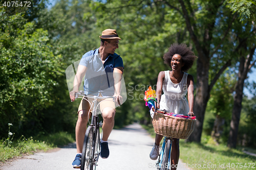 Image of Young multiethnic couple having a bike ride in nature