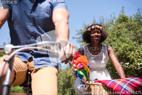 Image of Young multiethnic couple having a bike ride in nature