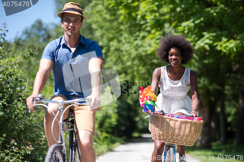 Image of Young multiethnic couple having a bike ride in nature