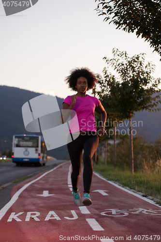 Image of a young African American woman jogging outdoors
