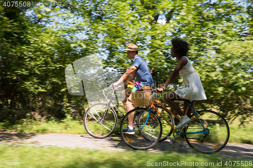 Image of Young multiethnic couple having a bike ride in nature