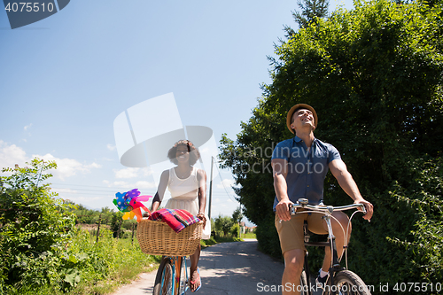 Image of Young multiethnic couple having a bike ride in nature
