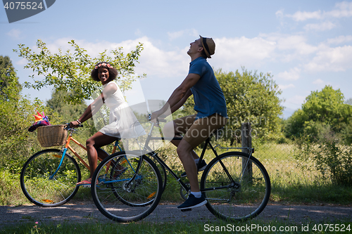 Image of Young multiethnic couple having a bike ride in nature