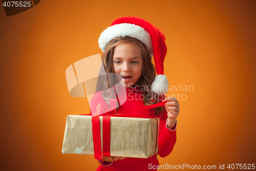 Image of The cute cheerful little girl on orange background