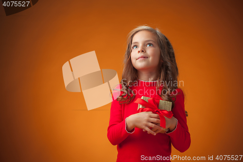 Image of The cute cheerful little girl on orange background