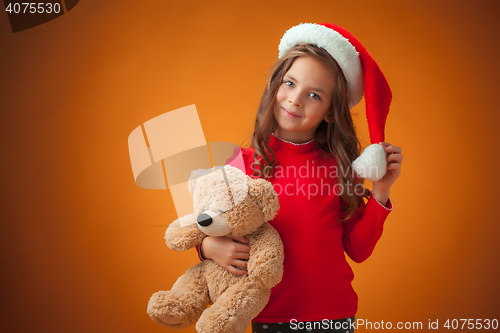 Image of The cute cheerful little girl on orange background