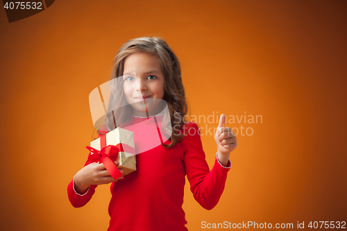 Image of The cute cheerful little girl on orange background