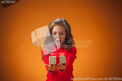 Image of The cute cheerful little girl on orange background