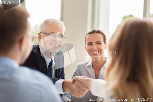 Image of senior businessman making handshake at office