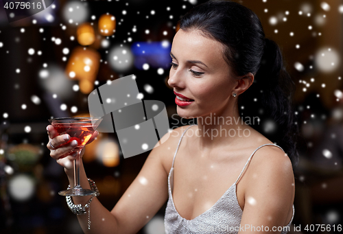 Image of glamorous woman with cocktail at night club or bar