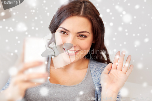 Image of happy young woman with smartphone at home