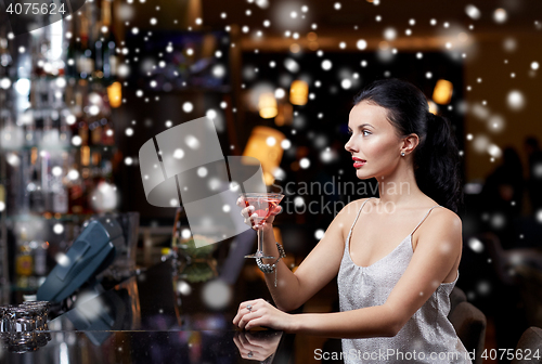 Image of glamorous woman with cocktail at night club or bar