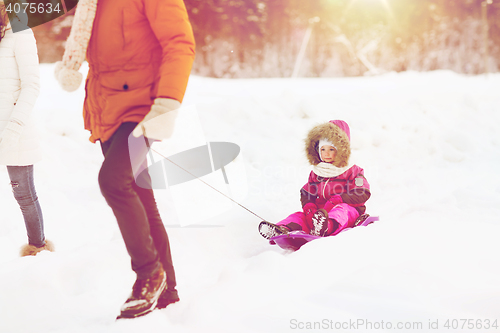 Image of happy family with sled walking in winter forest