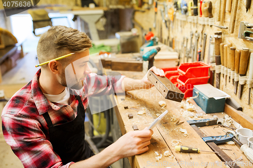 Image of carpenter working with wood plank at workshop