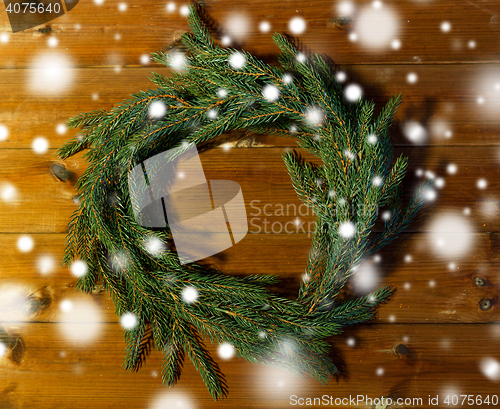 Image of natural green fir branch wreath on wooden board