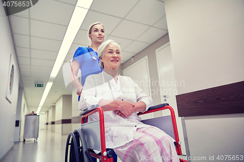 Image of nurse with senior woman in wheelchair at hospital