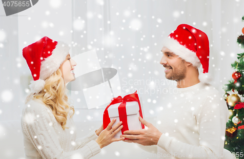 Image of happy couple at home with christmas gift box