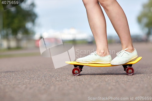 Image of close up of female feet riding short skateboard