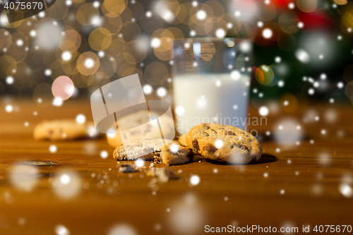 Image of close up of cookies and milk over christmas lights