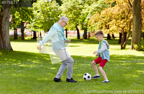 Image of old man and boy playing football at summer park