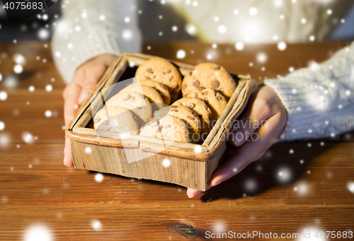 Image of close up of woman with oat cookies at home