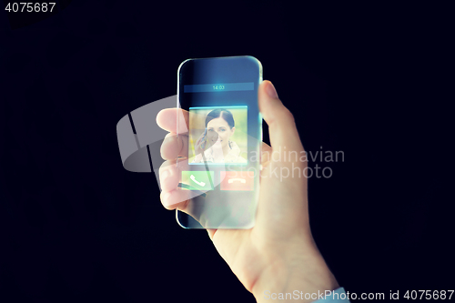 Image of close up of male hand with transparent smartphone