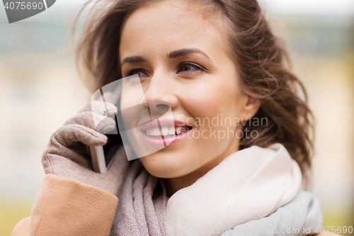 Image of woman calling on smartphone in autumn park