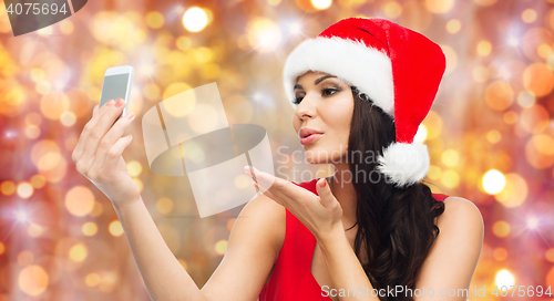 Image of woman in santa hat taking selfie by smartphone