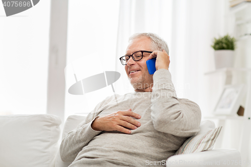 Image of happy senior man calling on smartphone at home