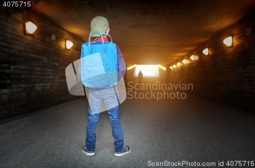 Image of School child walking in a dark subway