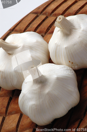 Image of three garlic on wood
