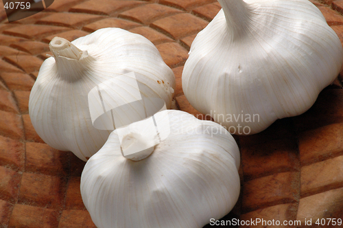 Image of three garlic on woode