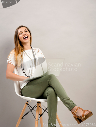 Image of Woman working a lapptop and laughing