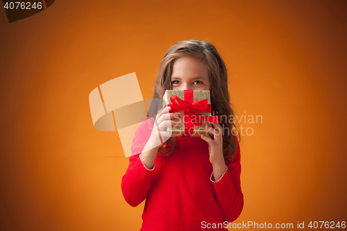 Image of The cute cheerful little girl on orange background