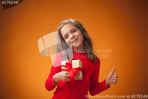 Image of The cute cheerful little girl on orange background