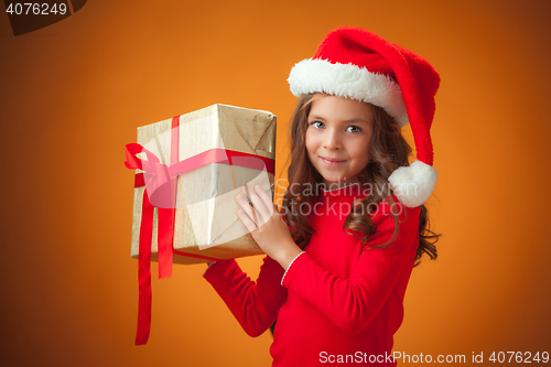Image of The cute cheerful little girl on orange background