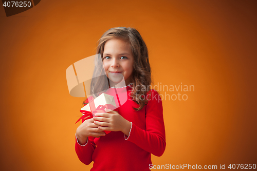 Image of The cute cheerful little girl on orange background