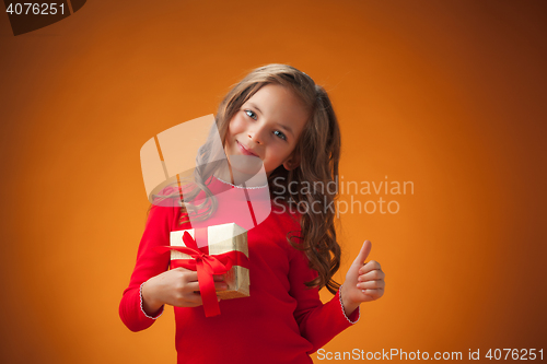 Image of The cute cheerful little girl on orange background