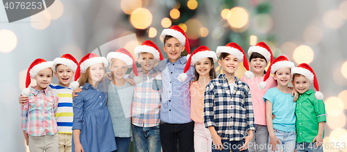 Image of happy smiling children in santa hats hugging