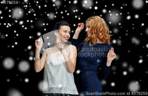 Image of happy young women dancing at night club disco